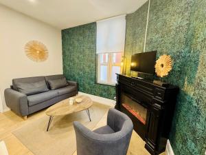 a living room with a couch and a fireplace at Le Besson, 2 pièces au cœur de la ville in Trouville-sur-Mer