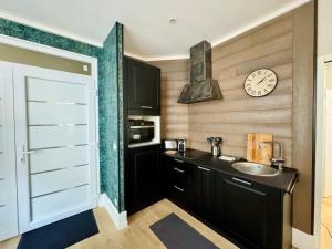 a bathroom with a sink and a clock on the wall at Le Besson, 2 pièces au cœur de la ville in Trouville-sur-Mer +6 photos