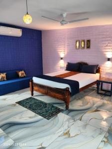 a bedroom with a king sized bed and a couch at BLUE Bay resorts in Yelagiri
