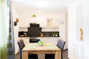 Una cocina con una mesa y sillas de madera. en Wildgrün Panorama Lodge 1, en Pfronten