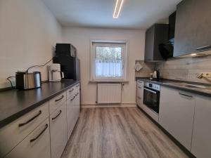 a kitchen with white cabinets and black counter tops at Haus Peter Wohnung 4 in Sankt Andreasberg