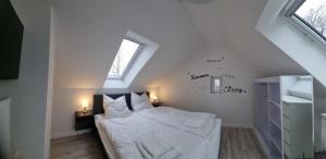 a bedroom with a bed with white sheets and a window at Haus Peter Wohnung 4 in Sankt Andreasberg