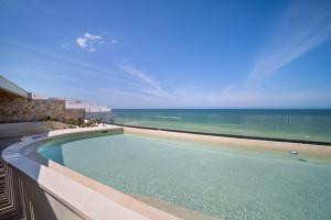 a swimming pool with a view of the ocean at 4 Bedroom Siela Beachfront Luxury Apartment in San Bruno