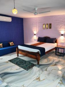 a bedroom with a king sized bed and a couch at BLUE Bay resorts in Yelagiri