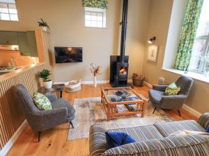 Una sala de estar con un sofá y una estufa de leña. en Old Howgate Barn, en Ambleside