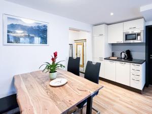 Una cocina y un comedor con mesa y sillas de madera. en Wildgrün Panorama Lodge 18, en Pfronten