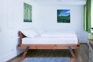 un dormitorio con una cama con sábanas blancas en Wildgrün Panorama Lodge 18, en Pfronten