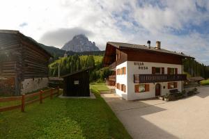 a building with a mountain in the background at Apartments Villa Rosa in Selva di Val Gardena