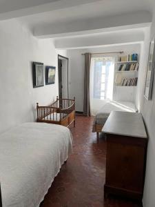a bedroom with two beds and a window at La Maison Joly in Ménerbes