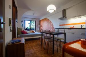 a kitchen and a living room with a table and chairs at Appartamento Velocipede in Cervignano del Friuli
