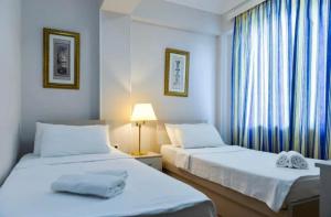 two beds in a hotel room with a window at Grand Central in Tsqaltubo