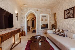 a living room with a couch and a tv at Via Regia Cappadocia Hotel in Uchisar