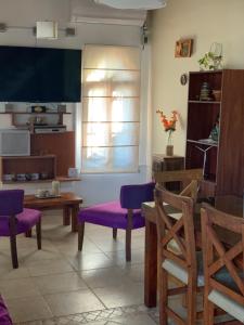 a living room with purple chairs and a window at Chalet en Villa Gesell in Villa Gesell