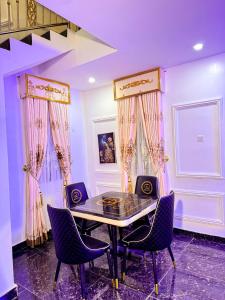 a dining room with a glass table and chairs at Cozy & Serene Sanctuary -The Paletinos Homes in Umuahia