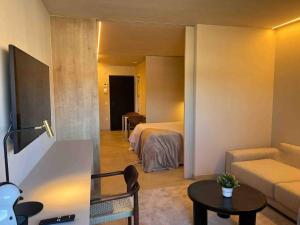 a room with a bed and a couch and a table at Piscina con Glamour in Murcia