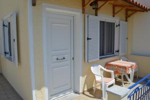 a balcony with a table and chairs and a door at Elli Studios & Apartments in Marathokampos