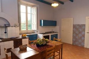 a kitchen with a wooden table and a dining room at Holiday House Taormina in Trappitello