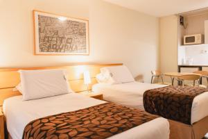 a hotel room with two beds and a table at Punta Trouville Hotel in Montevideo +61 photos