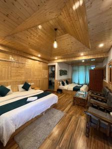 una camera con due letti in una stanza con soffitti in legno di Hotel Neelgiri - Manali Diaries a Manāli