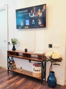un televisor colgado en una pared sobre un escritorio en Cosy central studio Calea Victoriei, en Gara Bucureşti Nord