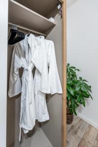 a white robe hanging on a shelf in a closet at Garbo 3 bedroom Kosice Centrum Very NEW in Košice