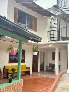 a patio with a yellow couch and potted plants at Hotel Campestre, El Balcón in Santa Bárbara
