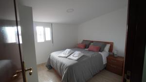 Un dormitorio con una cama con dos toallas encima. en A Xanota, en Combarro