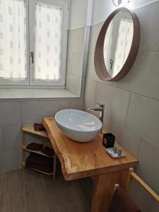 a bathroom with a bowl sink on a wooden table at Casa vacanze Angeli Custodi in Baselga di Pinè +6 photos