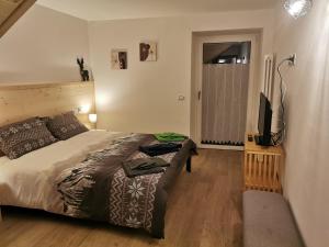 a bedroom with a bed and a flat screen tv at Casa vacanze Angeli Custodi in Baselga di Pinè