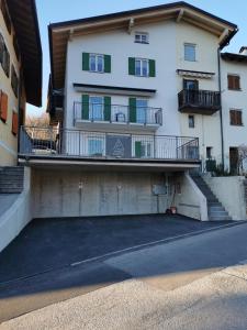 a large white building with balconies on a street at Casa vacanze Angeli Custodi in Baselga di Pinè