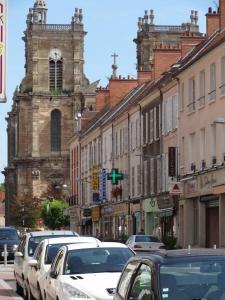 a city street with cars parked in front of a church at ApartHotel François 1er - 16ème in Vitry-le-François