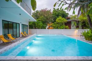 una piscina con sedie e una casa di Ton Sai Tropical Phi Phi Island a Phi Phi Don
