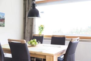 a dining room with a table and chairs and a window at Wildgrün Maxi Lodge 7 in Pfronten