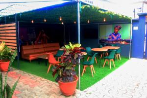 a patio with a table and chairs and a bar at Ringruby Hotel, Sangotedo in Sangotedo