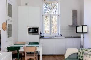 a white kitchen with a table and chairs and a window at Finca La Casería APARTAMENTOS in Cangas de Onís