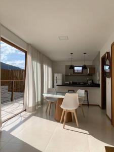 a kitchen and dining room with a table and chairs at Villa Andorinha, Ap Vista para Montanha in Mucugê