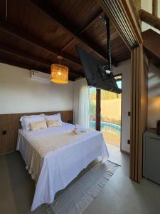 a bedroom with a large bed and a large window at Malie Bangalô - Alagoas in Barra de Santo Antônio +49 photos