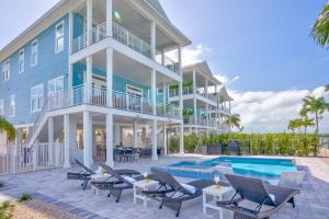 a large house with a swimming pool next to a building at New Oceanfront Luxury Home - Unit3 in Marathon