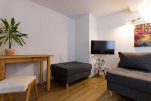 a living room with a couch and a table at Citystudio 3 Rosenburgblick in Moselnähe in Zeltingen-Rachtig +4 photos