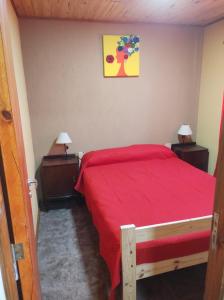 ein Schlafzimmer mit einem roten Bett und zwei Nachttischen in der Unterkunft complejo parenzo in Camet + 12 Fotos