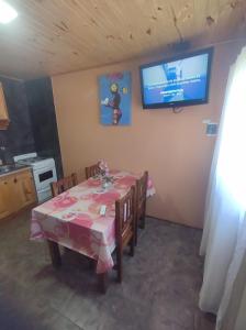 ein Esszimmer mit einem Tisch und einem Fernseher an der Wand in der Unterkunft complejo parenzo in Camet