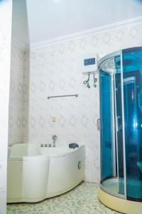 a bathroom with a tub and a shower at Ringruby Hotel, Sangotedo in Sangotedo