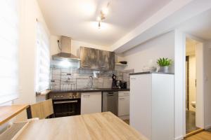 a kitchen with white cabinets and a wooden table at Citystudio 3 Rosenburgblick in Moselnähe in Zeltingen-Rachtig