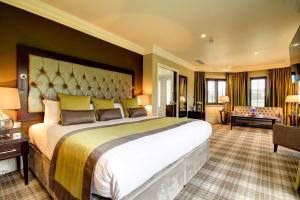 a large bedroom with a large bed and a living room at Ramside Hall Hotel, Golf & Spa in Durham