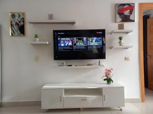 a tv hanging on a wall in a living room at Modern Boca Chica Beach Apartment with Sea View in Boca Chica