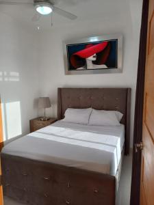 a bedroom with a bed and a painting on the wall at Modern Boca Chica Beach Apartment with Sea View in Boca Chica +71 photos