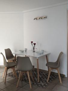 a dining room table with four chairs and a white table at Apartments in Vienna suburbs - 40 min from Vienna city center 