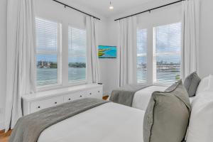 a white bedroom with two beds and two windows at New Oceanfront Luxury Home - Unit3 in Marathon +53 photos