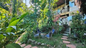a garden with chairs and a building at Eco Hostel Bosque di Barro in Ilha de Boipeba