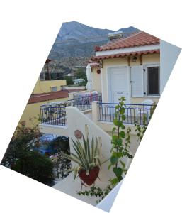 a house with a balcony with a potted plant at Elli Studios & Apartments in Marathokampos